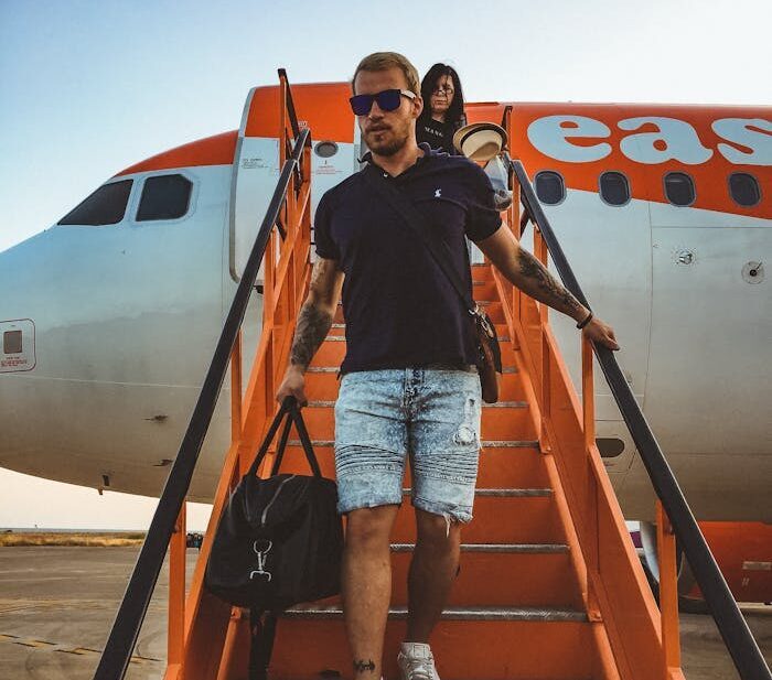 Casual travelers descending stairs from an EasyJet airplane, capturing a travel moment.